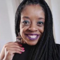 Amanda Silva, mulher negra de tranças longas, sorrindo, com batom roxo e brinco grande.