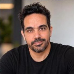 Eduardo Oliveira, homem de cabelos escuros e barba, vestindo camiseta preta.