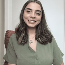 Rosi Bertaglia, mulher branca de cabelos castanhos na altura dos ombros, sorrindo, vestindo blusa verde, em ambiente interno